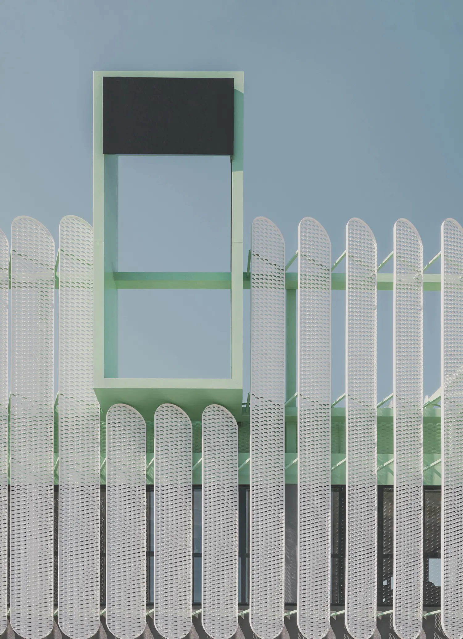Architectural detail of the mint green metal frame and vertical slats at Leganés Auto Center.