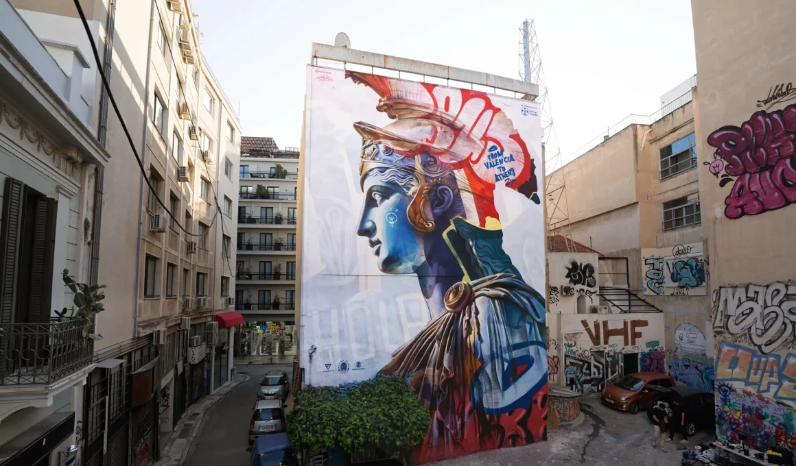 Wide street-level view of PichiAvo's Athena mural on Pallados Street in Athens.