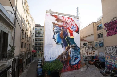 Wide street-level view of PichiAvo's Athena mural on Pallados Street in Athens.