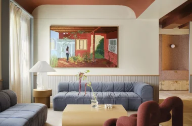 Modernist living room in Madrid with a burnt-orange vaulted ceiling, blue modular sofa, and large contemporary painting.