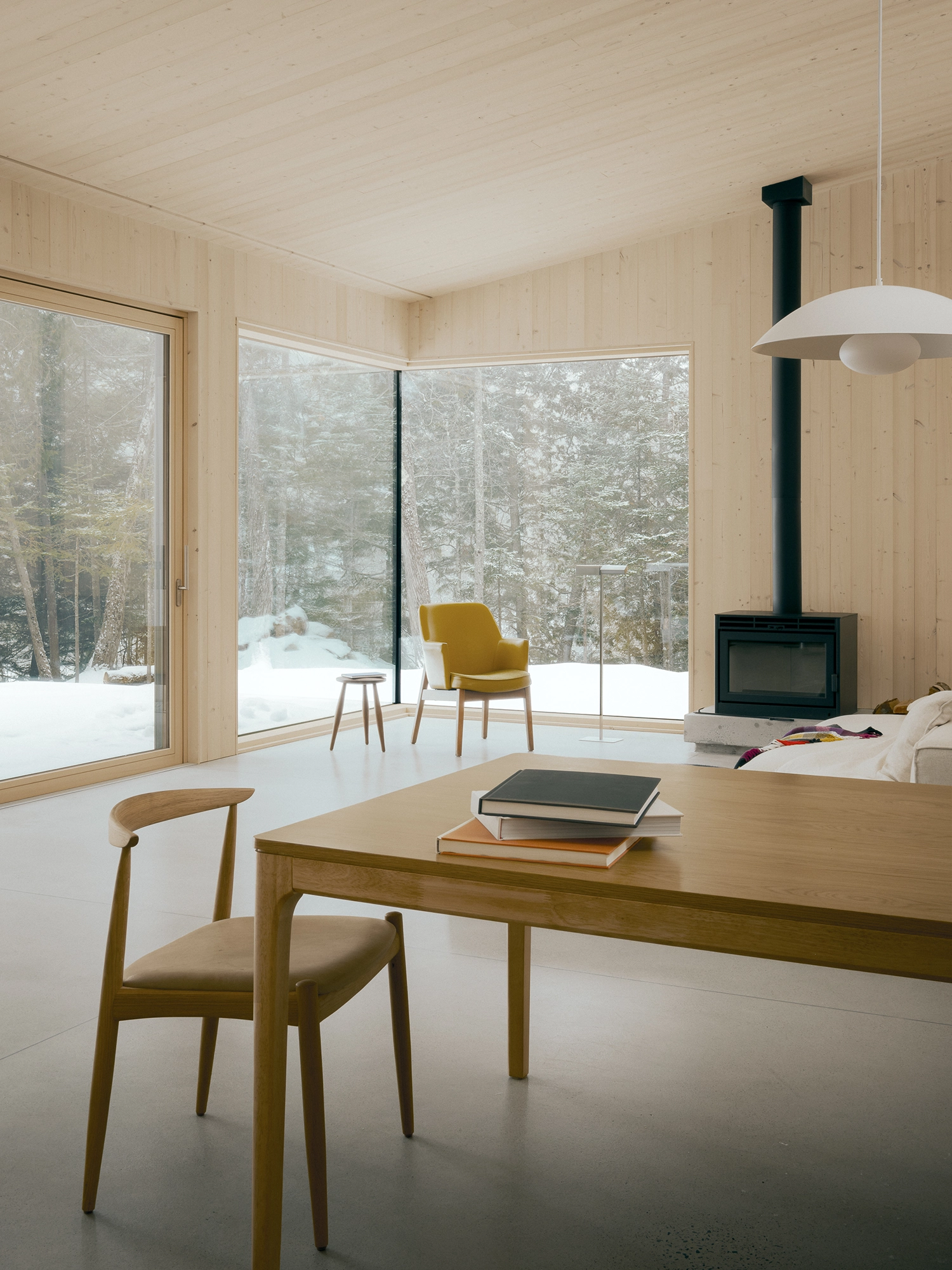 Cozy living area corner with a yellow armchair next to a large floor-to-ceiling window.