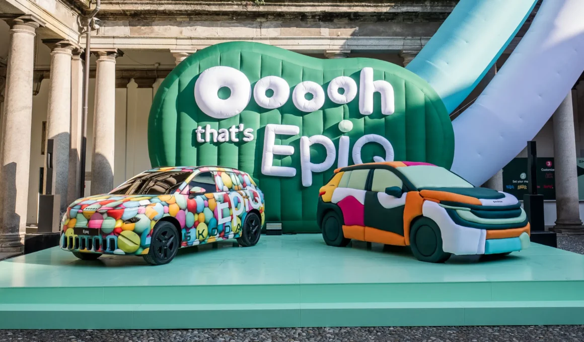 A camouflaged Škoda Epiq and the hand-shaped Epiq Sculpt on a green platform in front of a giant inflatable green backdrop reading "Ooooh that's Epiq".