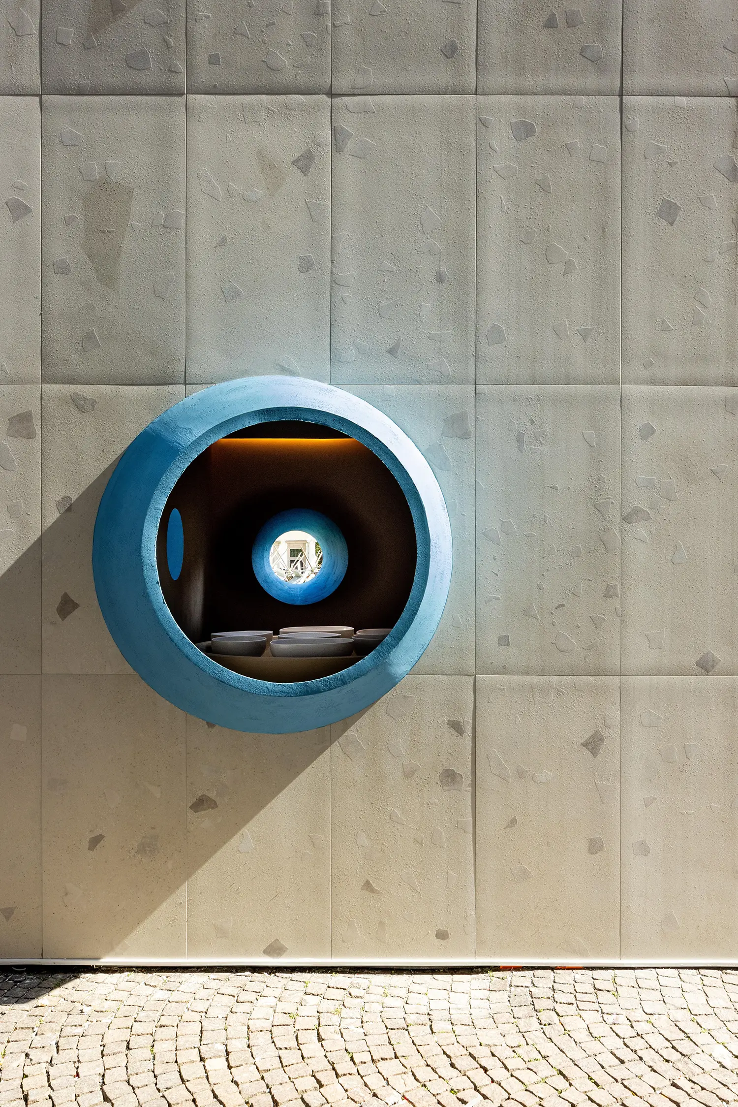 Tight close-up looking directly into the primary blue oculus on the textured wall.