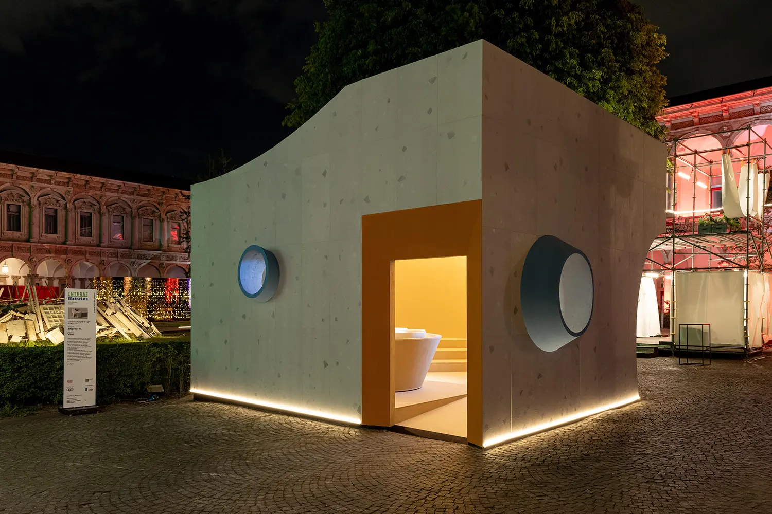 Wide exterior view of the glowing angular structure at night.