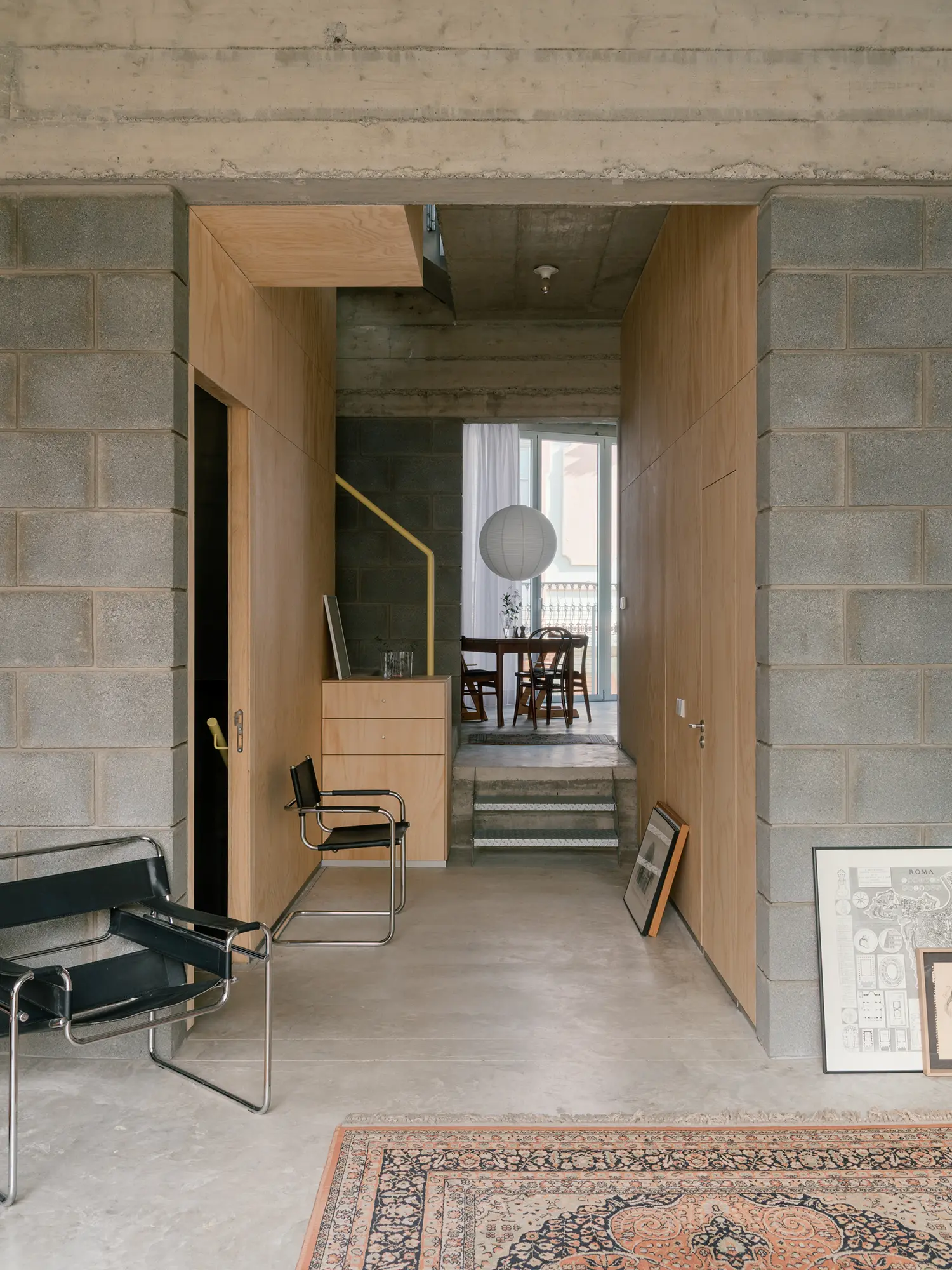 Interior view of Casa Iriarte showing volcanic block walls, timber partitions, and a glimpse into a dining area.