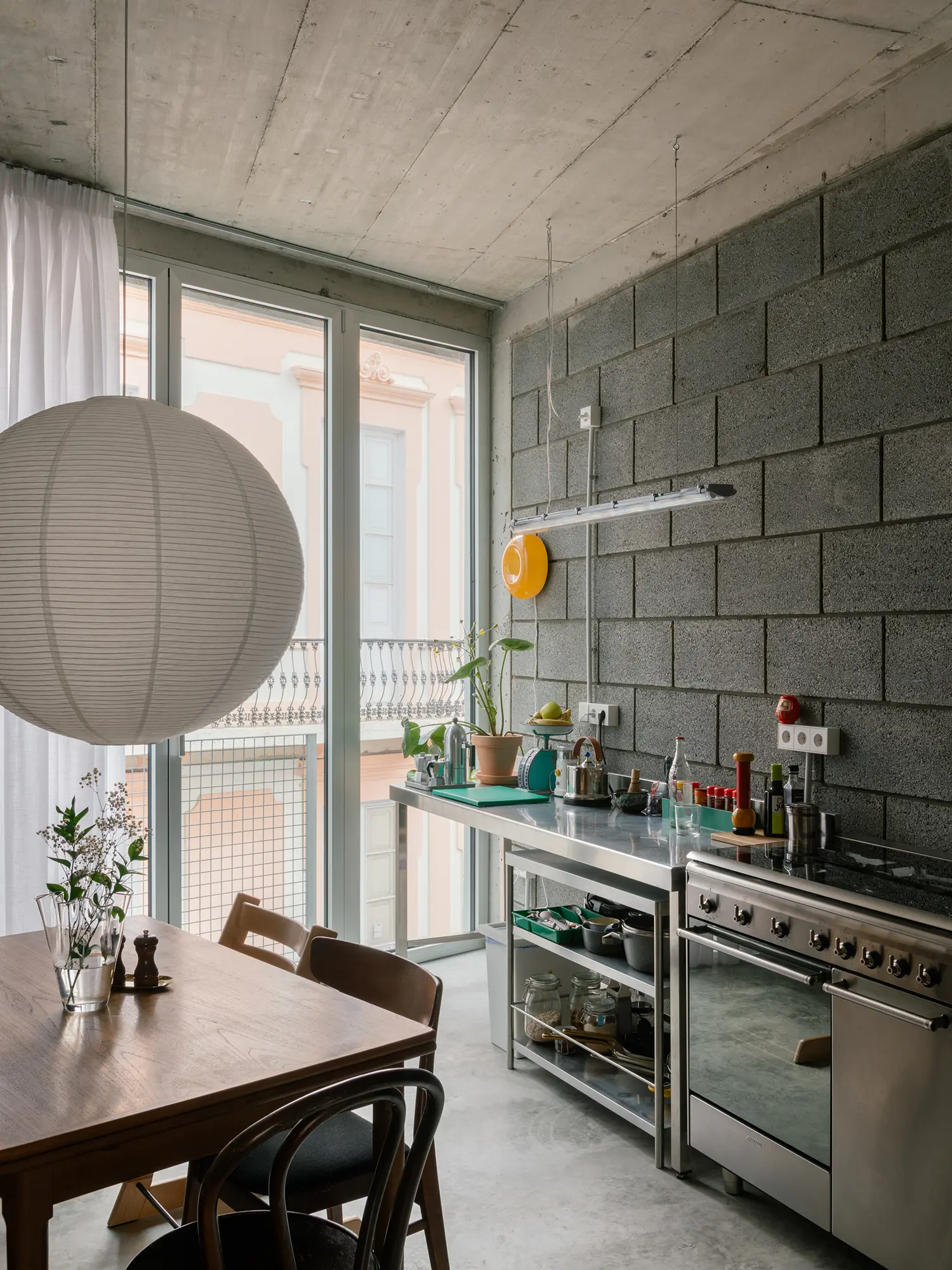 Industrial kitchen in Casa Iriarte with stainless steel counters and an exposed volcanic block wall.