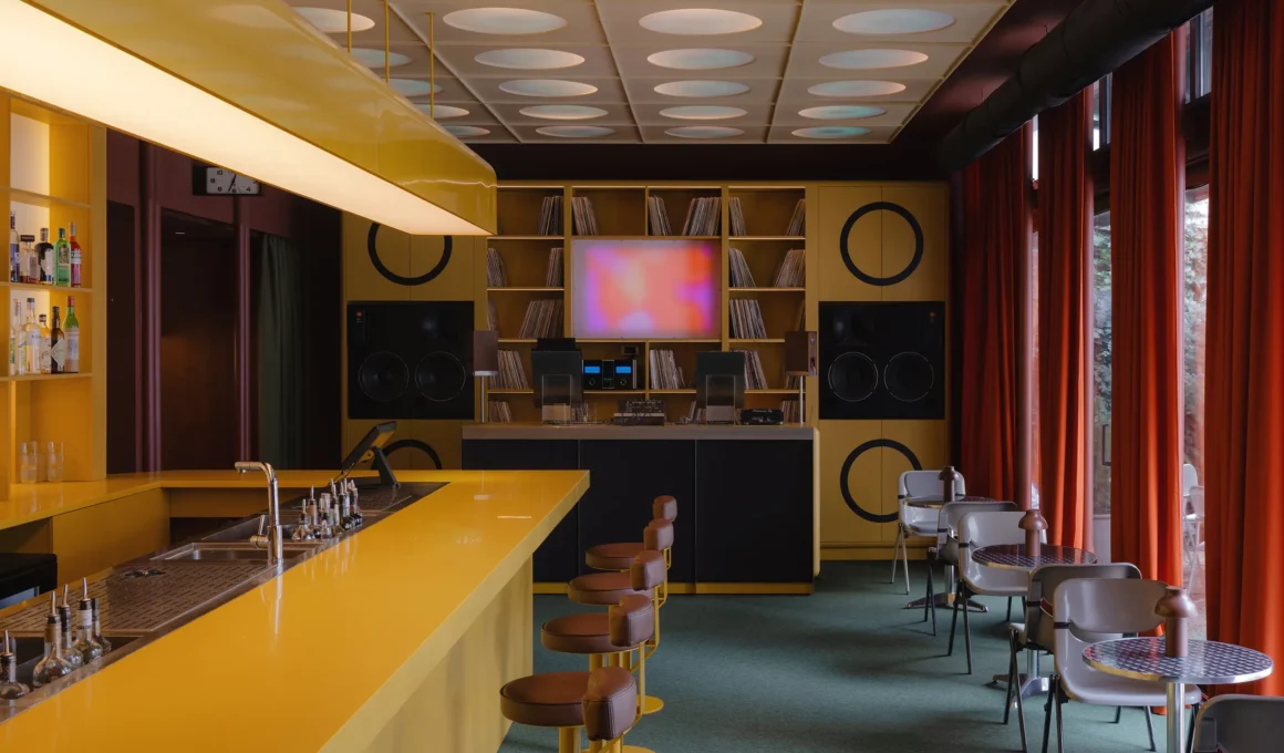 High-fidelity bar interior in Belgrade featuring a bold yellow counter and custom audio modules.