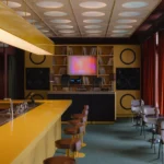 High-fidelity bar interior in Belgrade featuring a bold yellow counter and custom audio modules.
