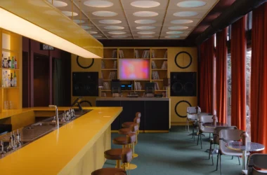 High-fidelity bar interior in Belgrade featuring a bold yellow counter and custom audio modules.