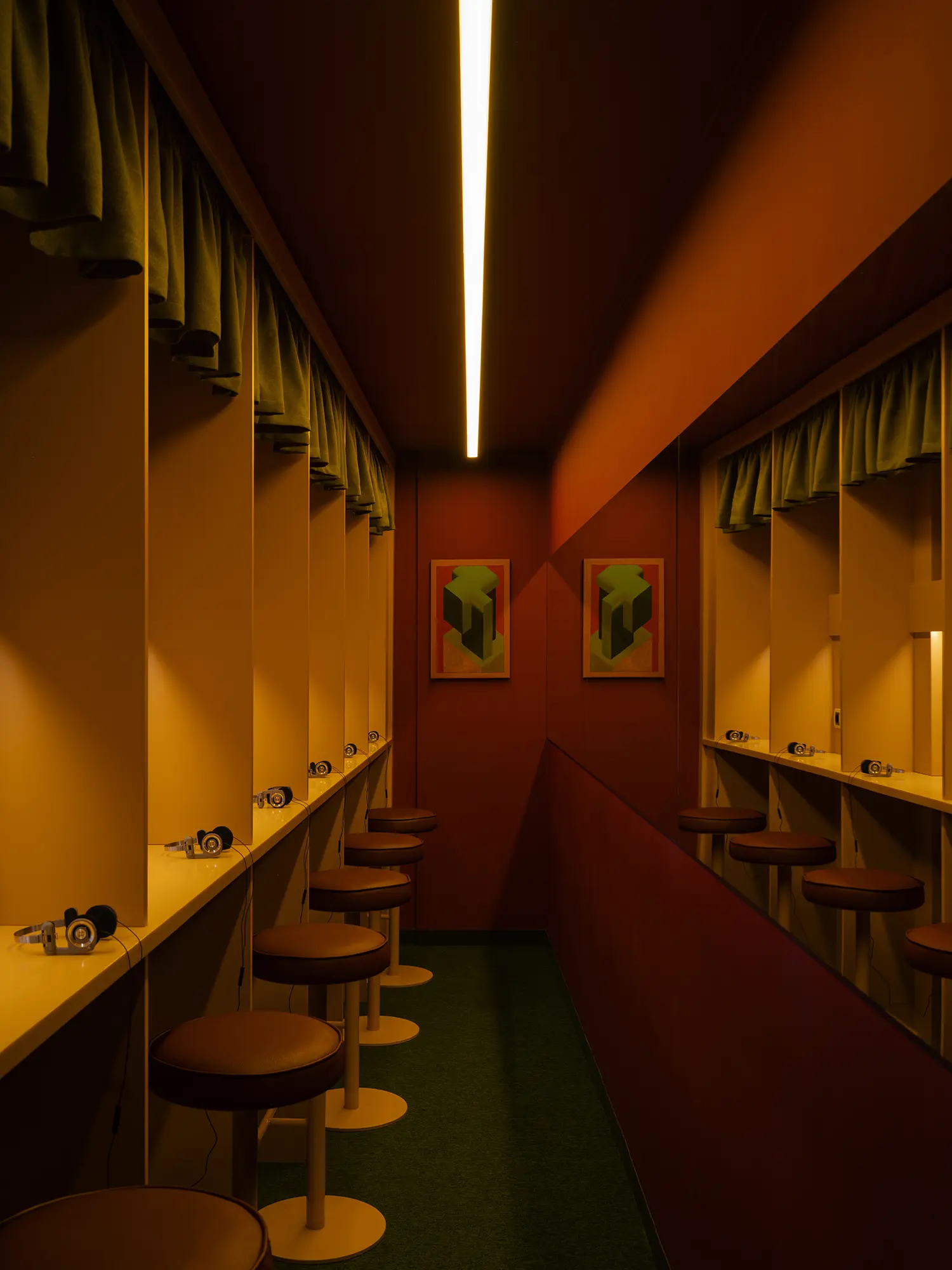 Individual listening booths at EJE Belgrade with headphones and green curtains.
