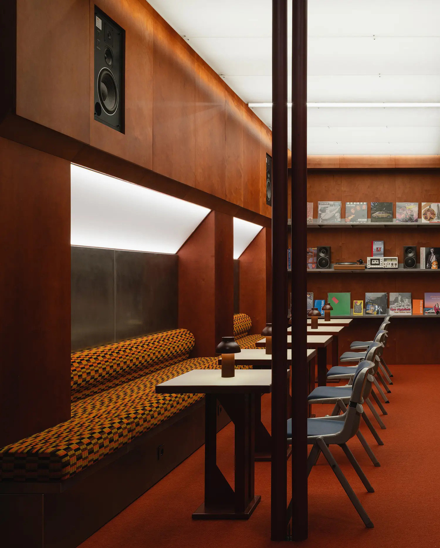 Dining area at EJE with wood-paneled walls and orange carpeting.