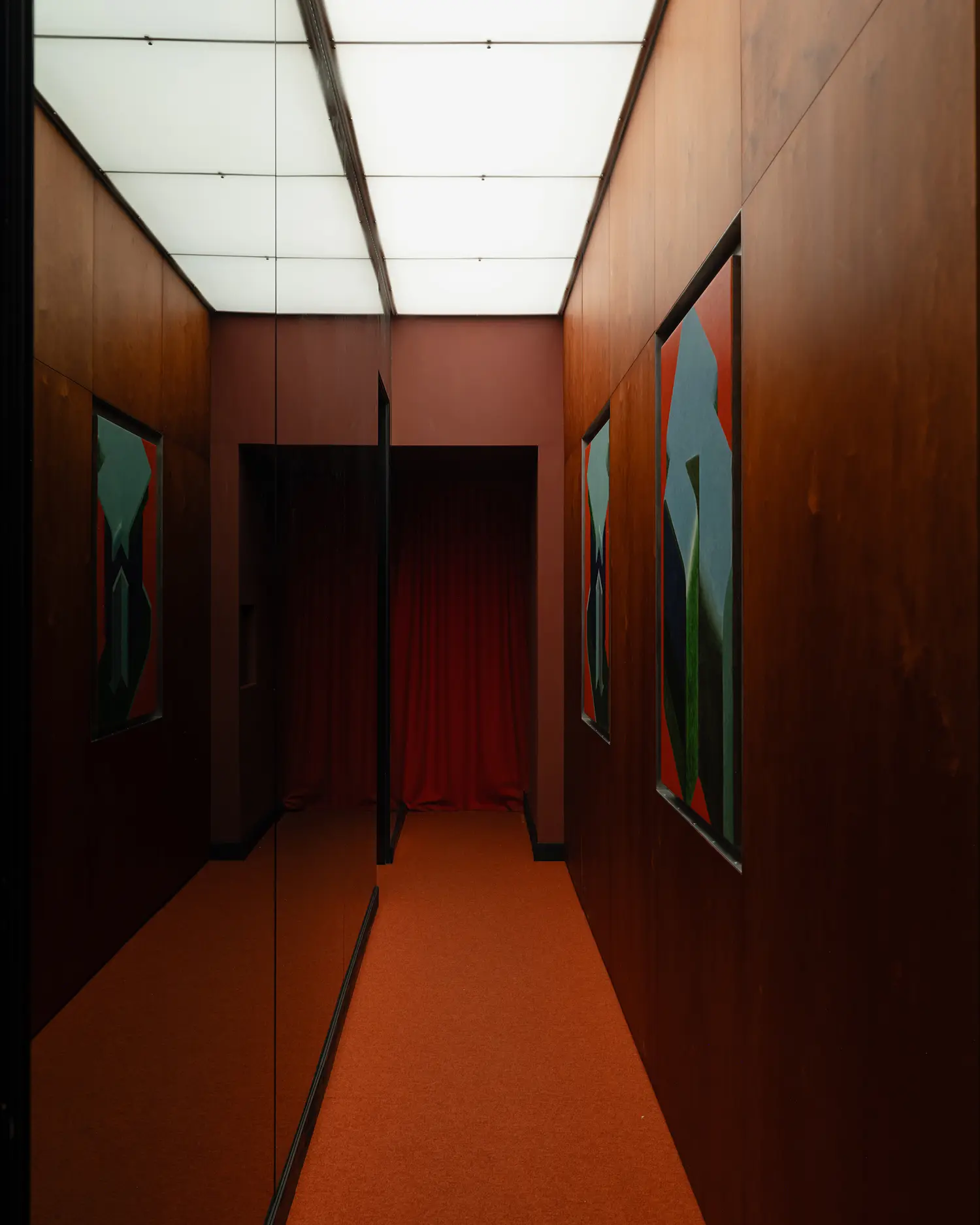 Mirrored hallway at EJE Belgrade with red curtains and abstract art.