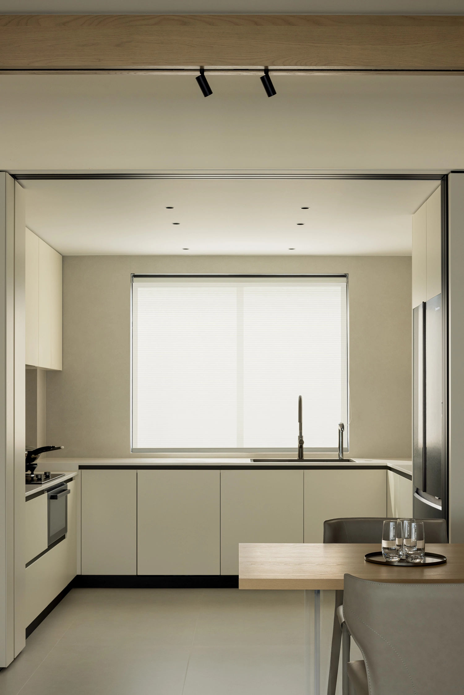 Minimalist white kitchen with a large window and integrated appliances in Linhai.