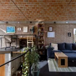 Interior view of a brick house living area with a vaulted brick ceiling and mezzanine office.