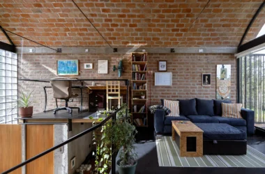 Interior view of a brick house living area with a vaulted brick ceiling and mezzanine office.