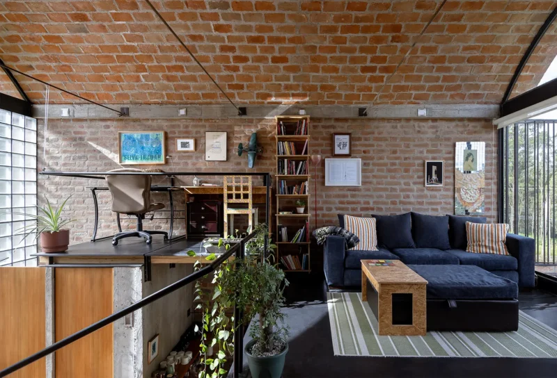 Interior view of a brick house living area with a vaulted brick ceiling and mezzanine office.
