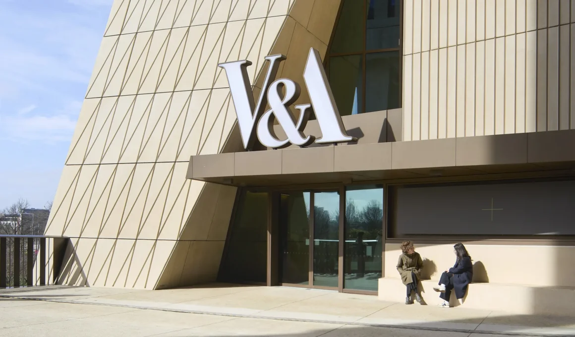 Close-up of the V&A East Museum entrance showing the sculptural concrete façade and bold V&A signage.