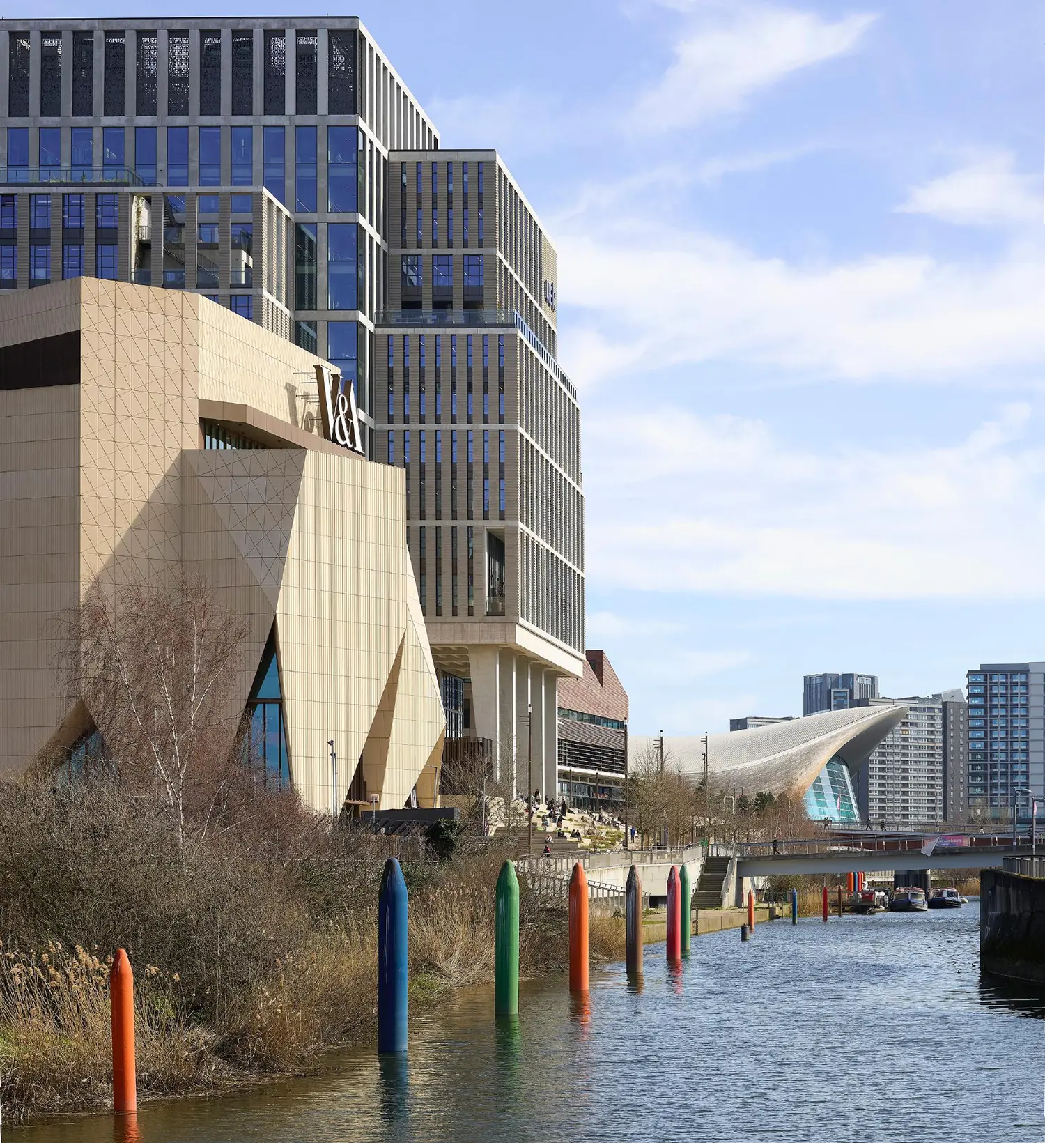 Wide shot of V&A East Museum from the waterfront, showing its relationship to the East Bank skyline.