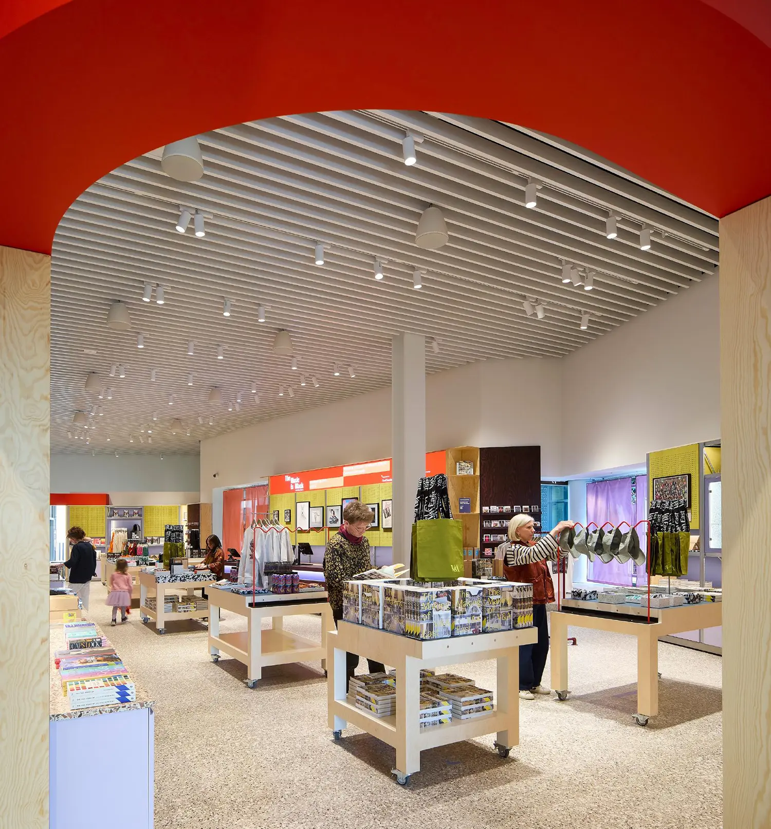 The V&A East Museum shop interior with plywood displays and industrial lighting.