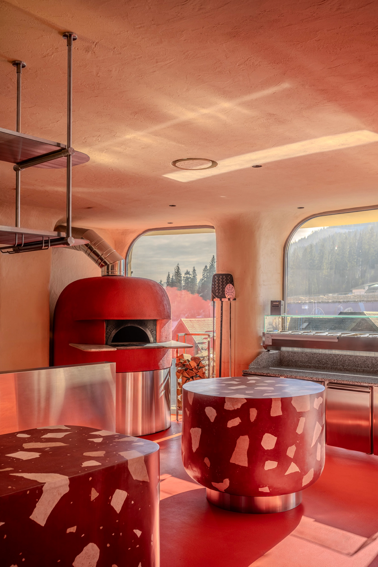 Red pizza oven and open kitchen focal point at Rosso Italian restaurant.