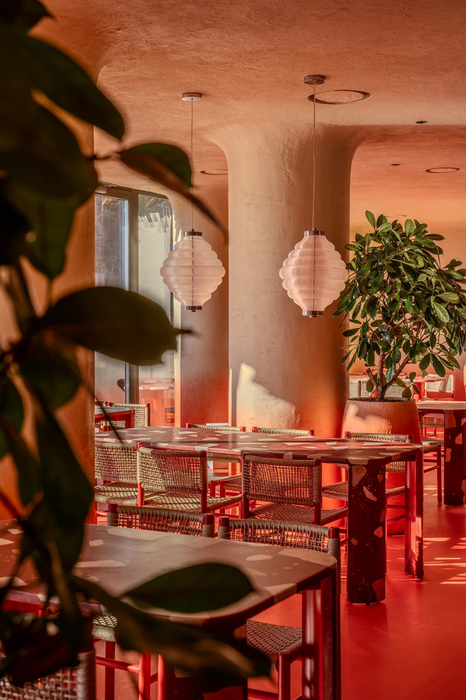 3D-printed pendant lights shaped like beehives hanging above dining tables.