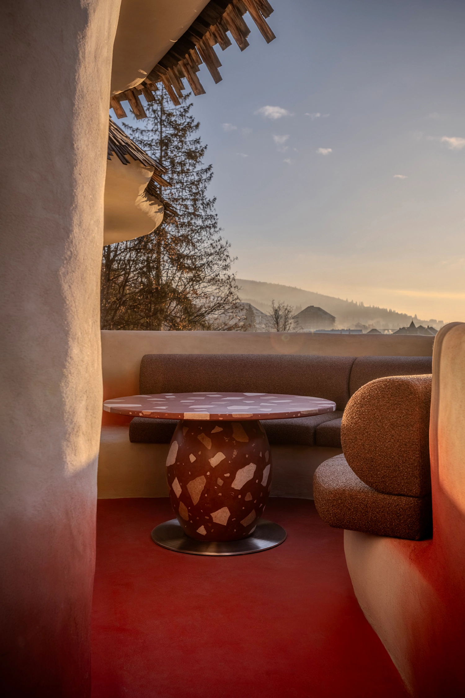 Outdoor terrace at Rosso with concrete terrazzo tables and mountain views.