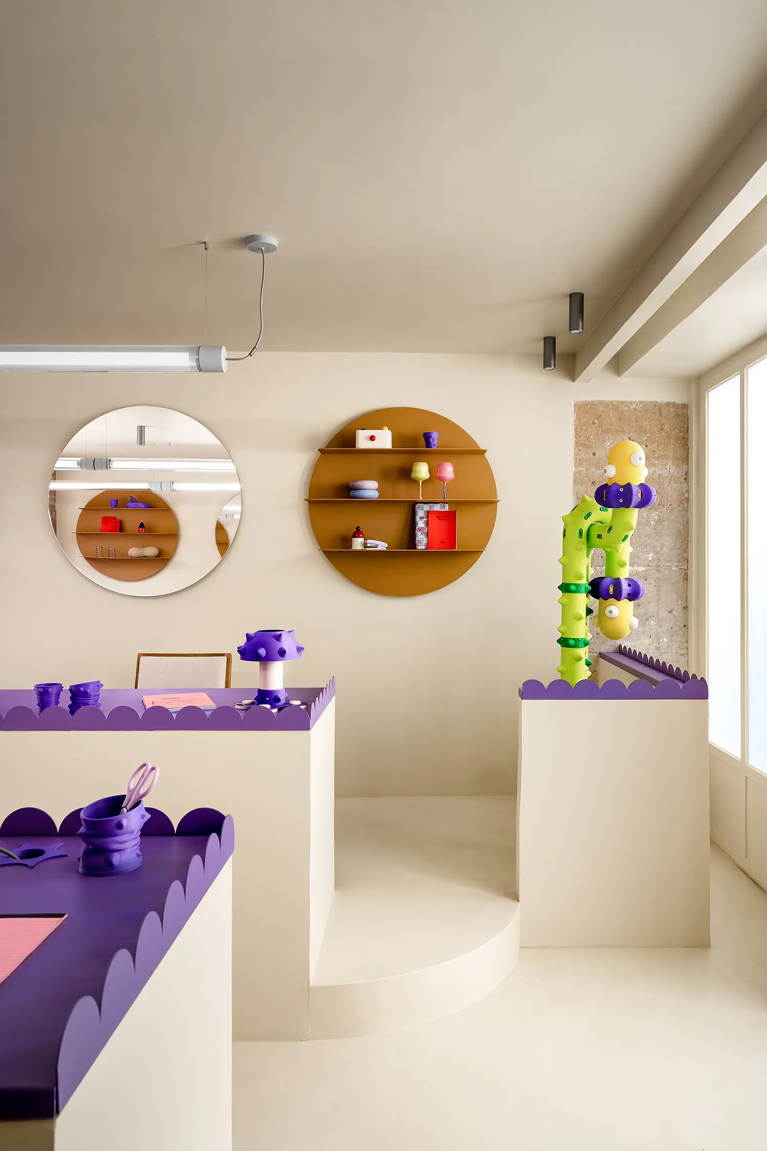 Lime green 3D-printed sculpture next to a purple partition and mustard-yellow circular shelves.