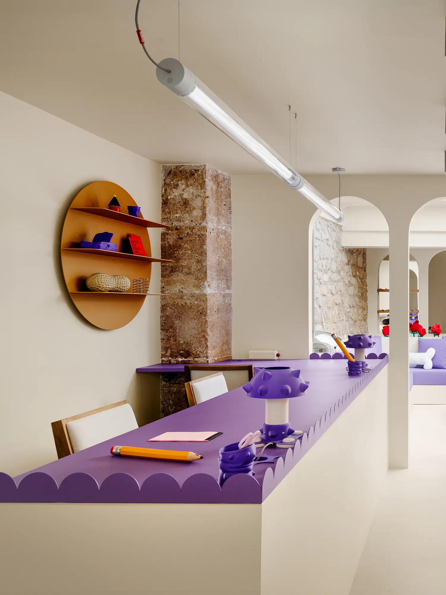 Scalloped purple desktop with oversized wooden pencils and a 3D-printed mushroom lamp.
