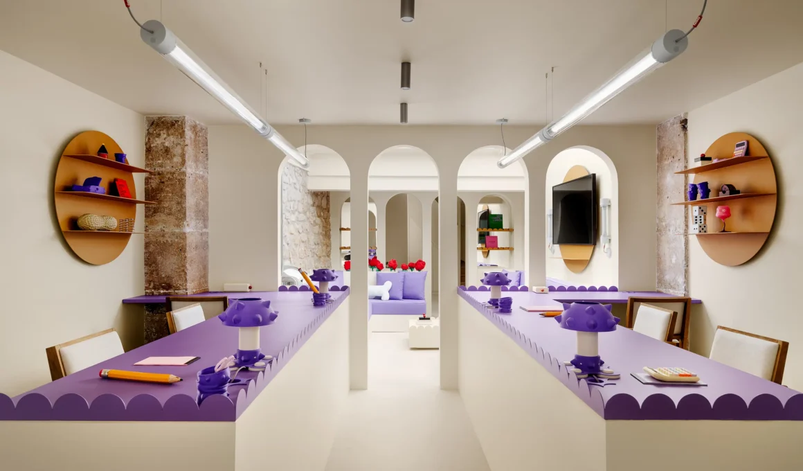 Symmetrical perspective of purple workstations and cream arches in Artus Office Paris.