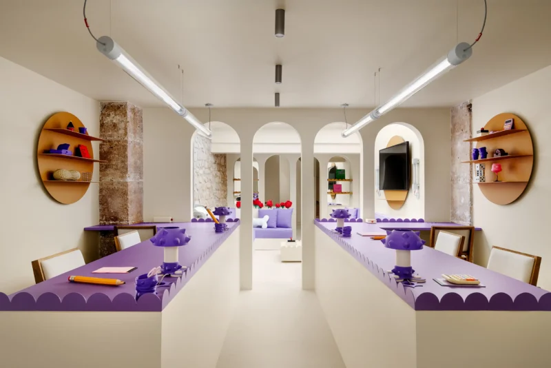 Symmetrical perspective of purple workstations and cream arches in Artus Office Paris.