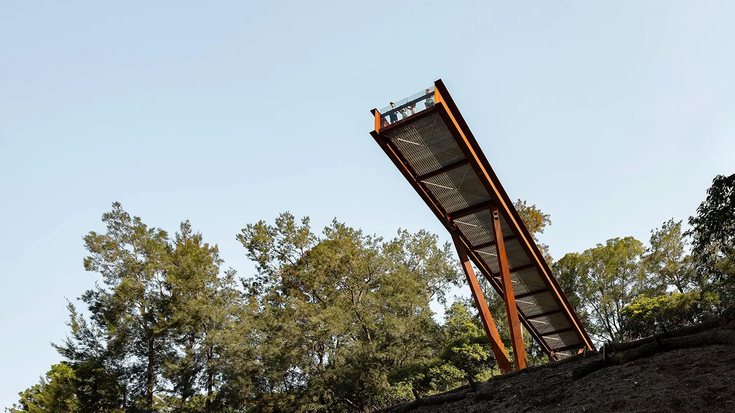 Side profile of the viewing platform showing the V-shaped angled columns supporting the weathering steel beam over the quarry edge.