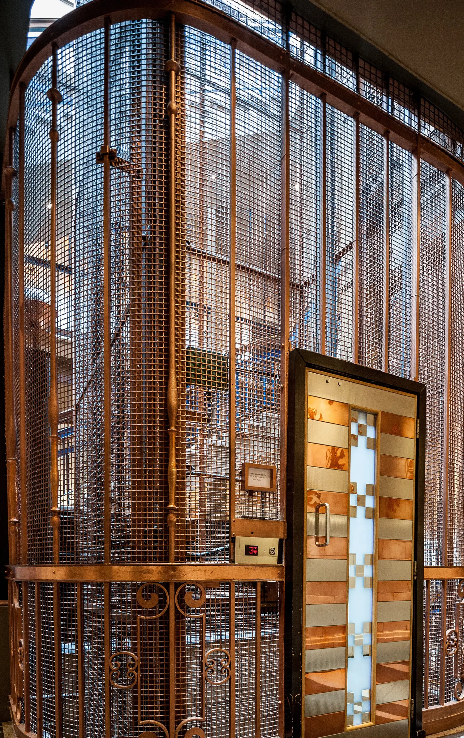 Original vintage birdcage lift with ornate metal mesh and bronze accents.