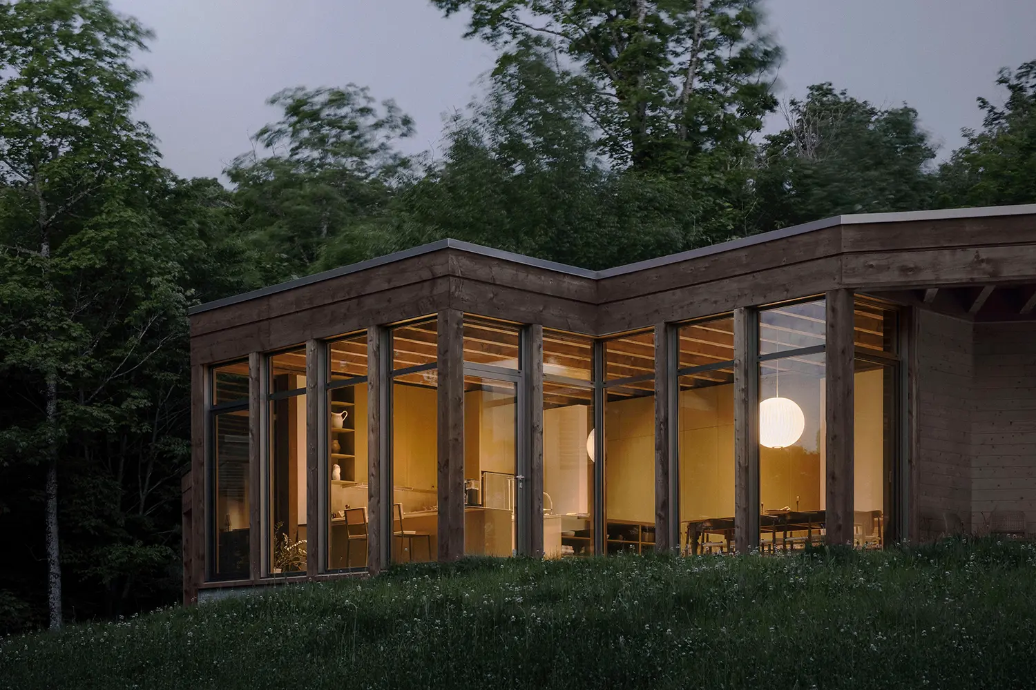 Atelier Carle SONO Residence dusk exterior reclaimed timber glazed volume kitchen dining Nelson pendant Quebec 2025
