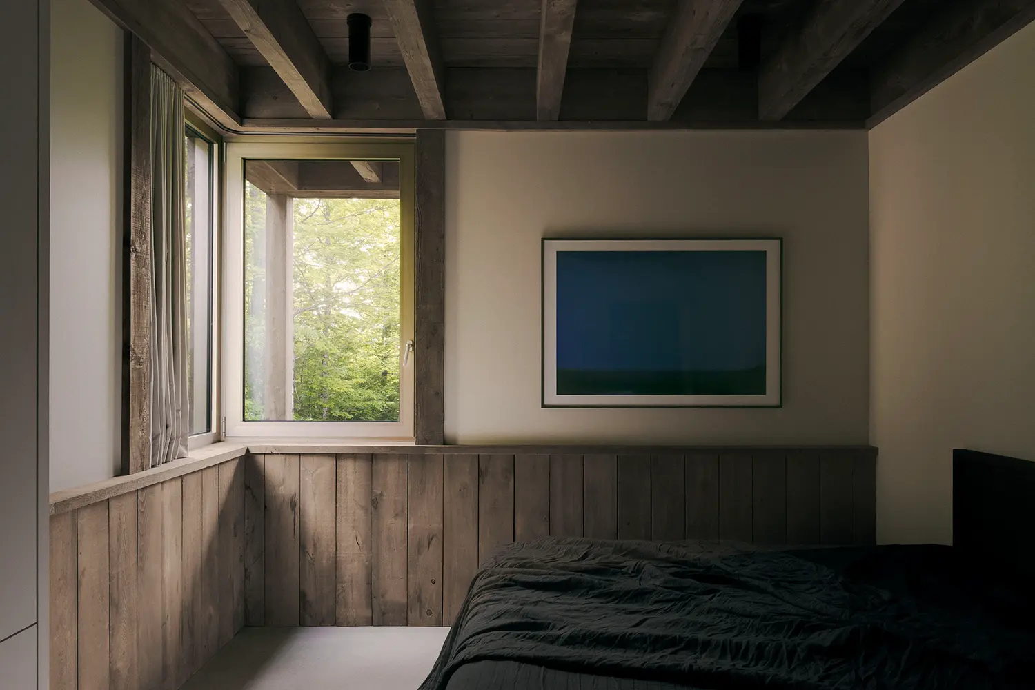 Atelier Carle SONO Residence bedroom reclaimed timber wall paneling corner window blue painting Quebec 2025