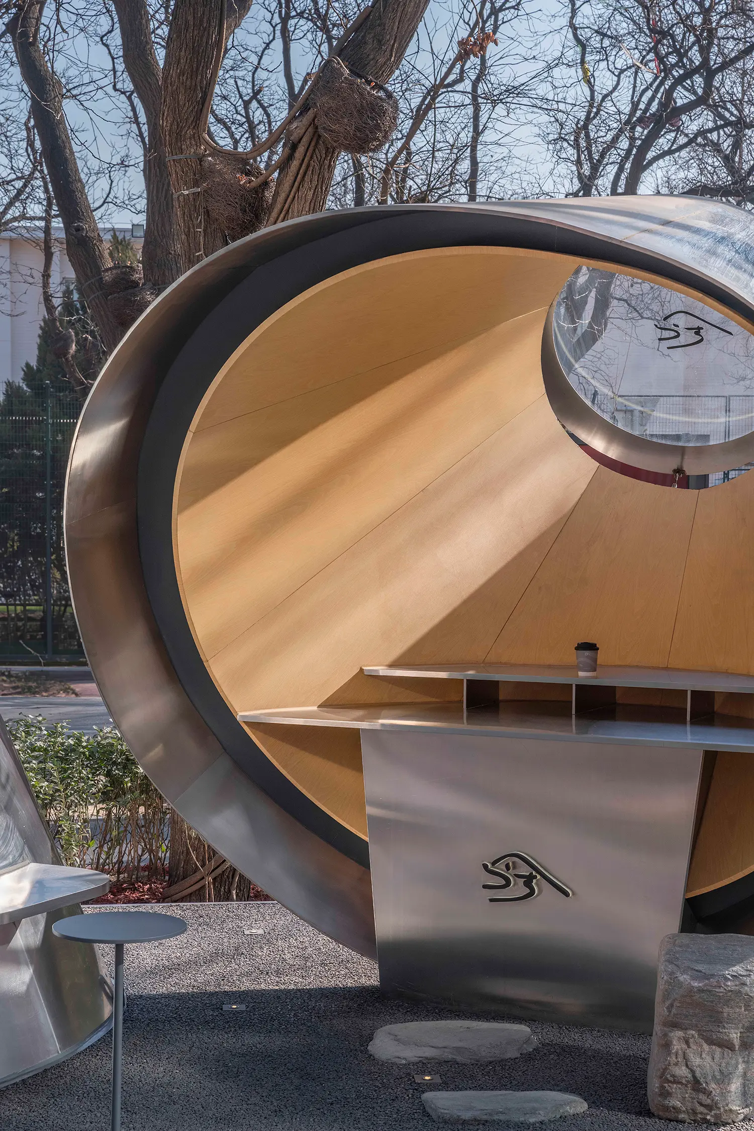 Detailed view of the cantilevered volume’s interior lined with light wood panels and featuring a circular window.