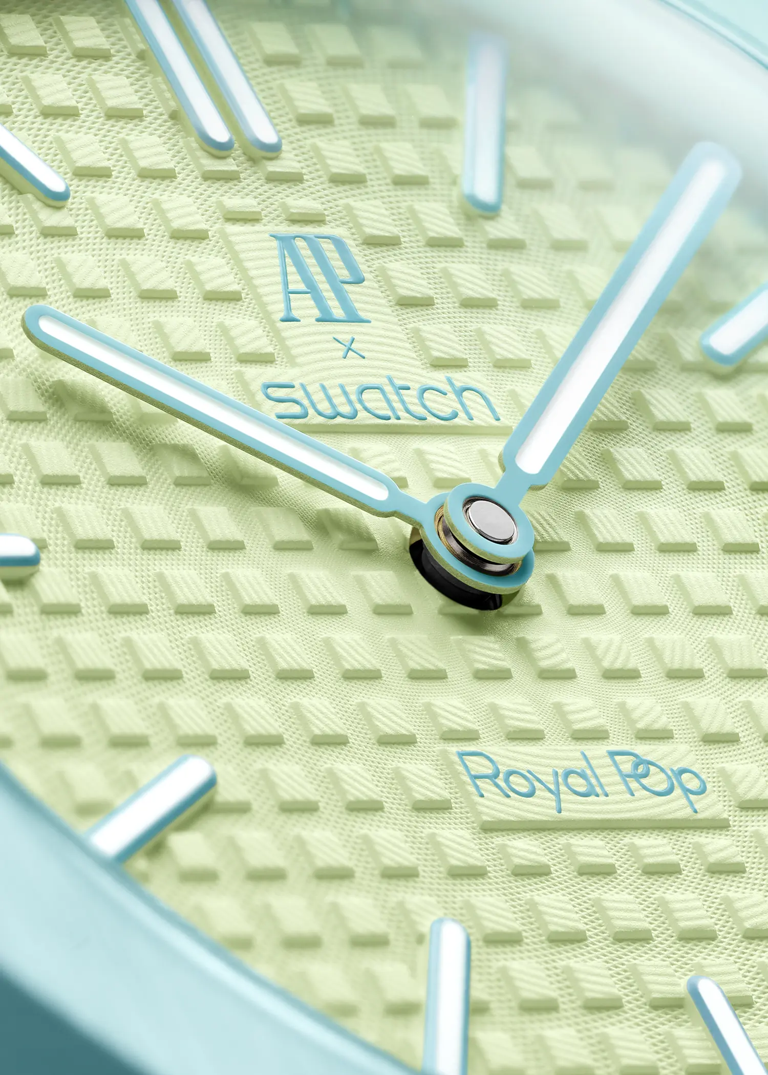 Macro shot of the pale green "Petite Tapisserie" dial with blue hands and AP x Swatch logo.