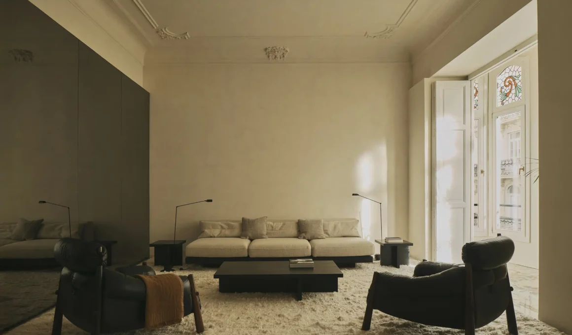 Balzar GE Apartment Valencia, living room with Art Nouveau plaster moldings, Sergio Rodrigues leather armchairs, low coffee table, stained glass balcony door