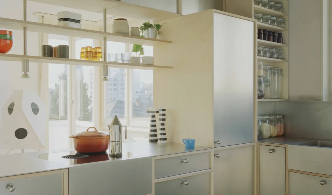 Noue Studio Fribourg apartment renovation, birch plywood and zinc kitchen joinery, open shelving with metal supports, zinc countertop, checkerboard tile floor