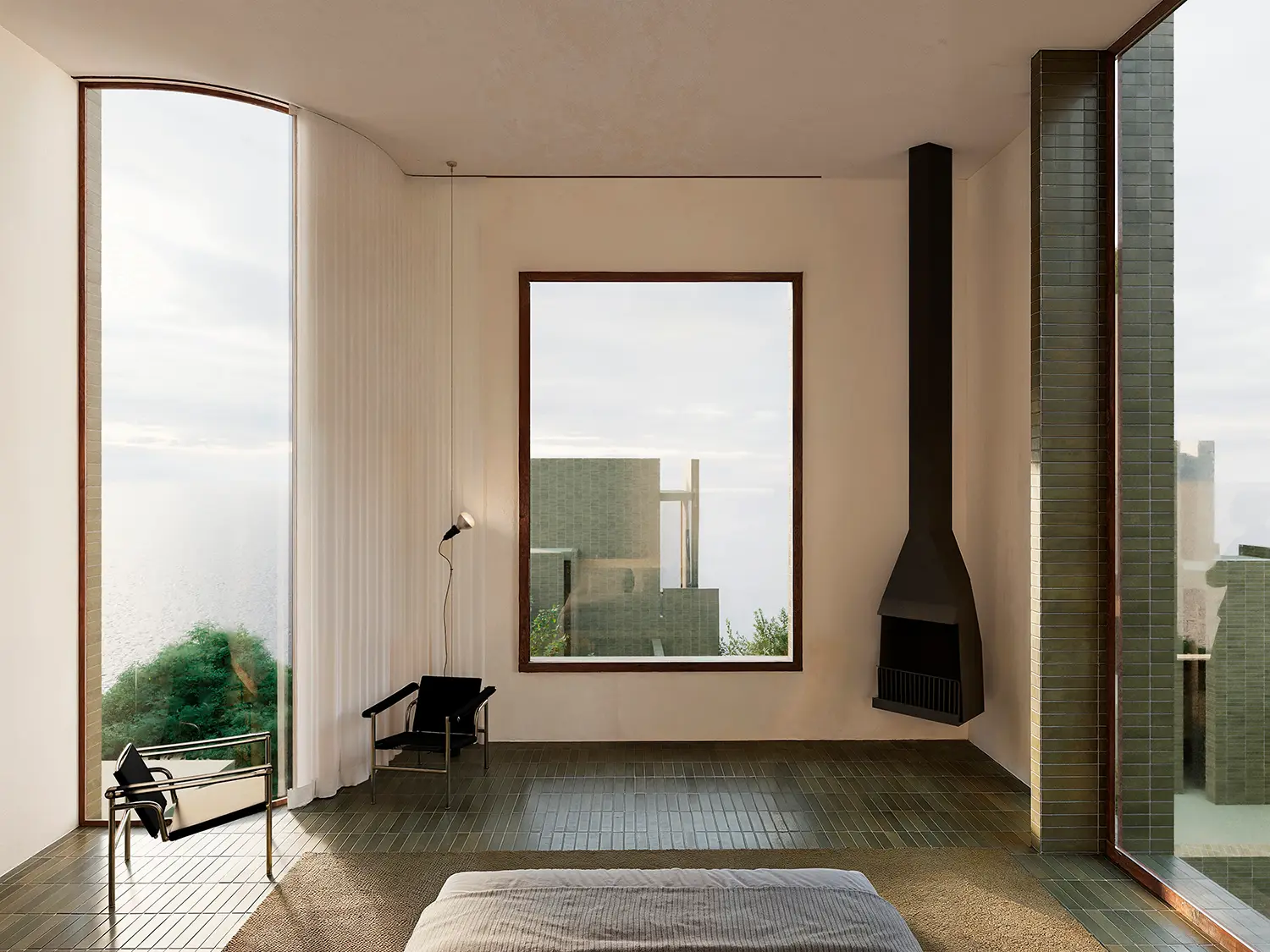 Minimalist master bedroom interior with green tiled flooring and sea views at The Veil.