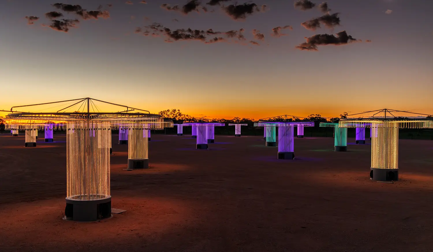 Multiple fiber-optic light stands by Bruce Munro scattered across the red earth in Wentworth, Australia.