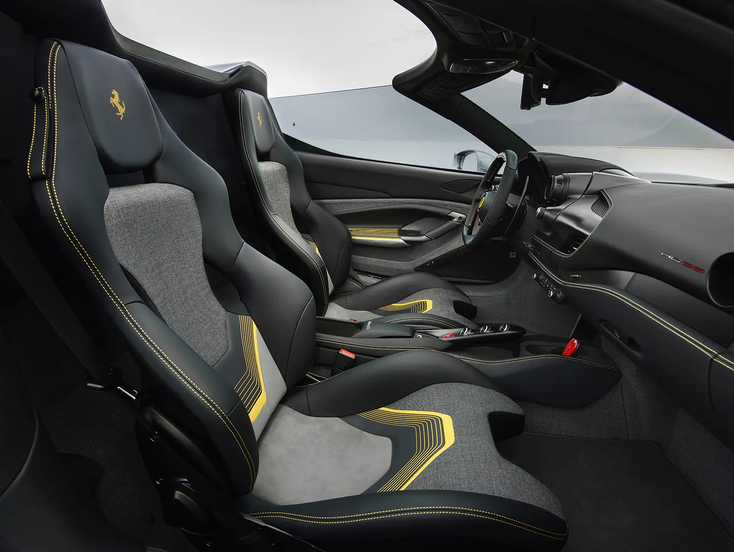 Close-up of the grey and black sports bucket seats inside the Ferrari HC25 with yellow geometric patterns.