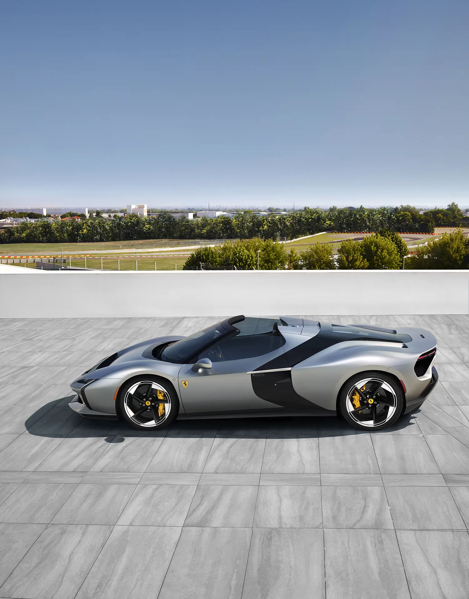 Full side profile of the silver Ferrari HC25 open-top spider showing the continuous black ribbon design element.