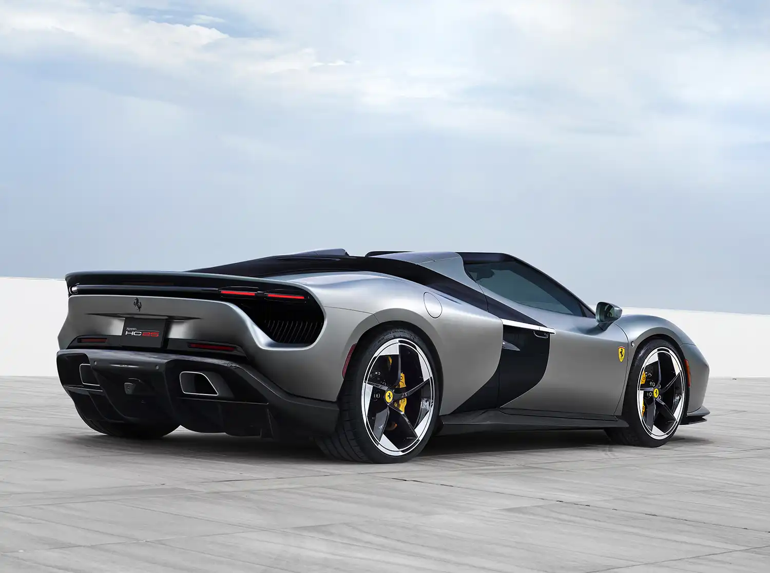 Rear three-quarter low-angle view of the silver Ferrari HC25 spider showing the rear diffuser and slim horizontal taillights.
