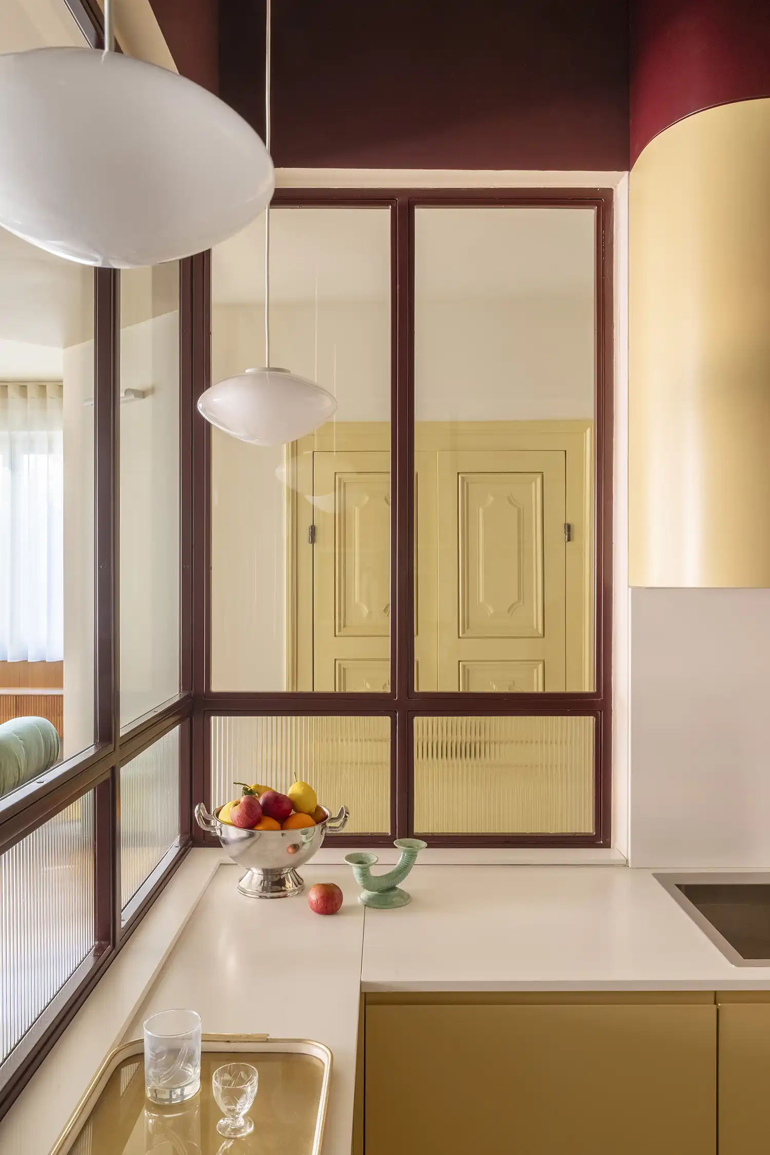 Casa Continua Rome by STUDIOTAMAT, burgundy metal framed glass partition with reeded lower panels, kitchen interior