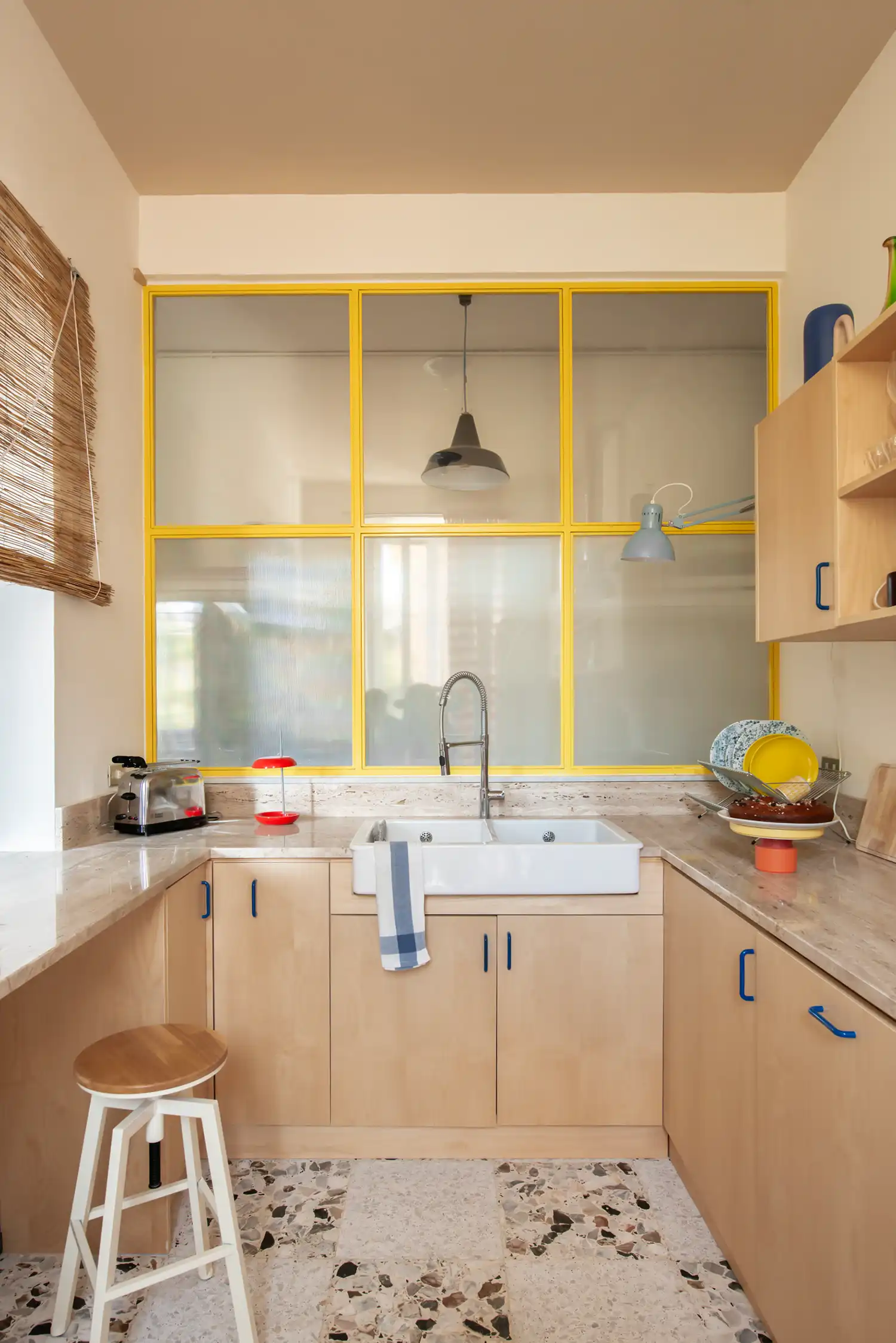 Station123 Rome by 02A Studio, yellow metal framed frosted glass partition, kitchen with terrazzo floor and birch cabinets