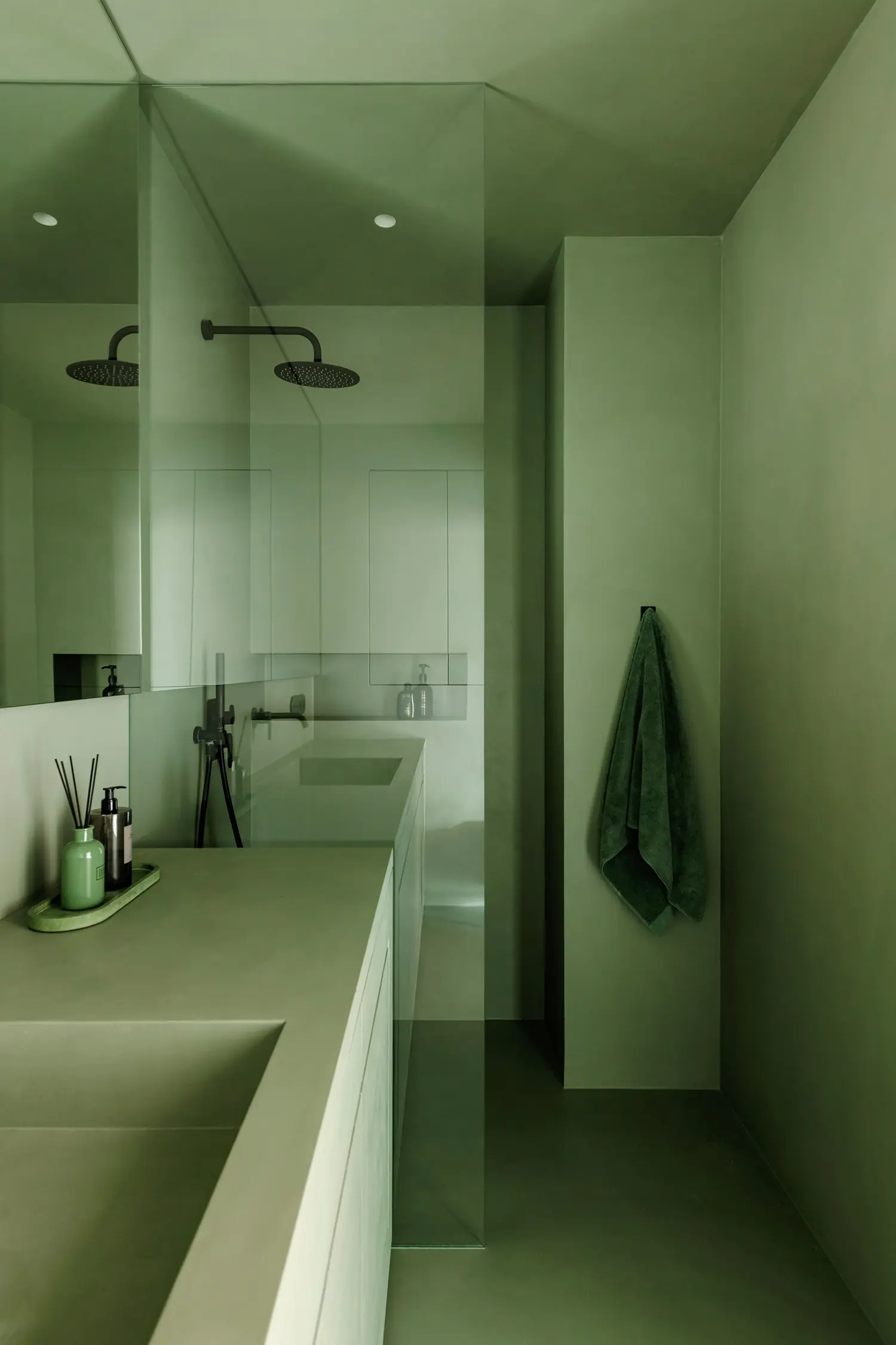 Sage green monochrome microcement bathroom with matte black shower and full-height glass partition, Grzybowska apartment Warsaw, Dawid Konieczny Interiors