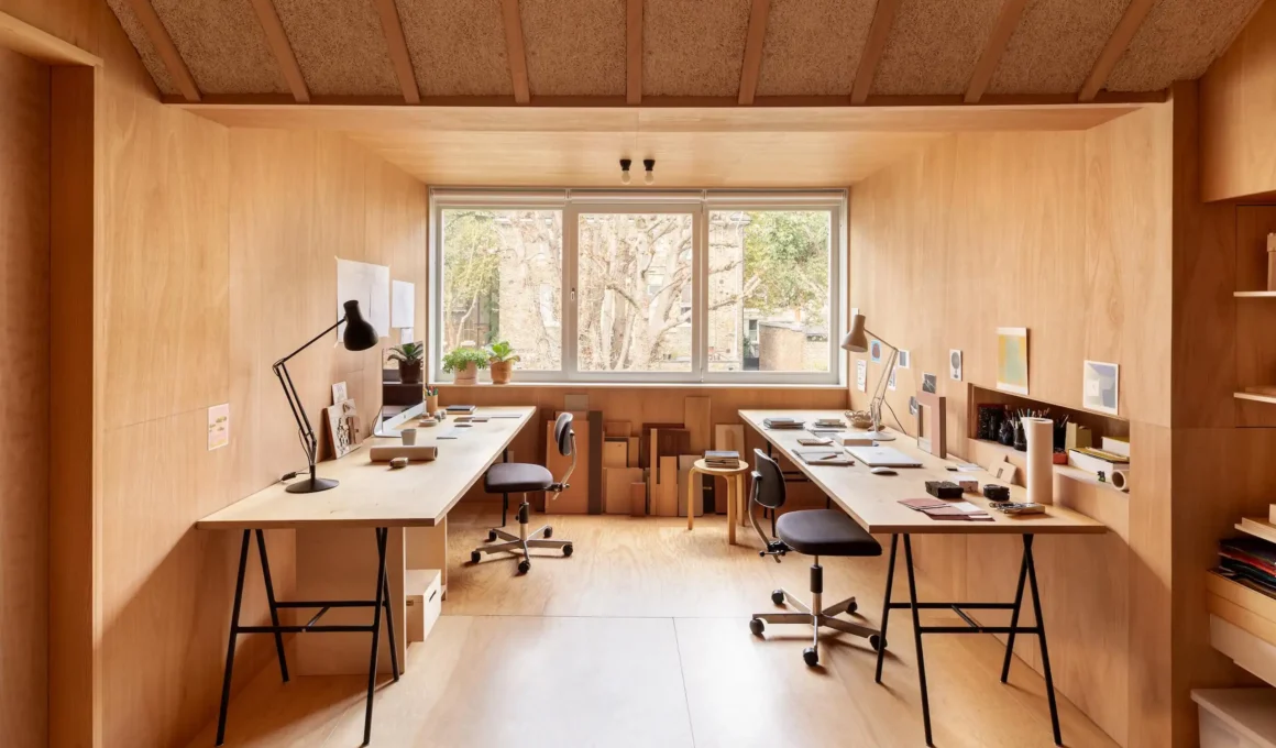 Birch plywood attic studio with dual desks, shelving and north-facing window, Elmhurst Canonbury House, O'Sullivan Skoufoglou Architects