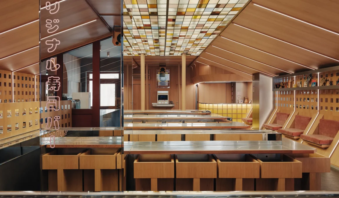 A symmetrical interior view of Matsuri Marseille restaurant featuring custom oak dining counters, a central conveyor belt system, a stained-glass ceiling, and a mirrored pillar with glowing Japanese neon graphics.