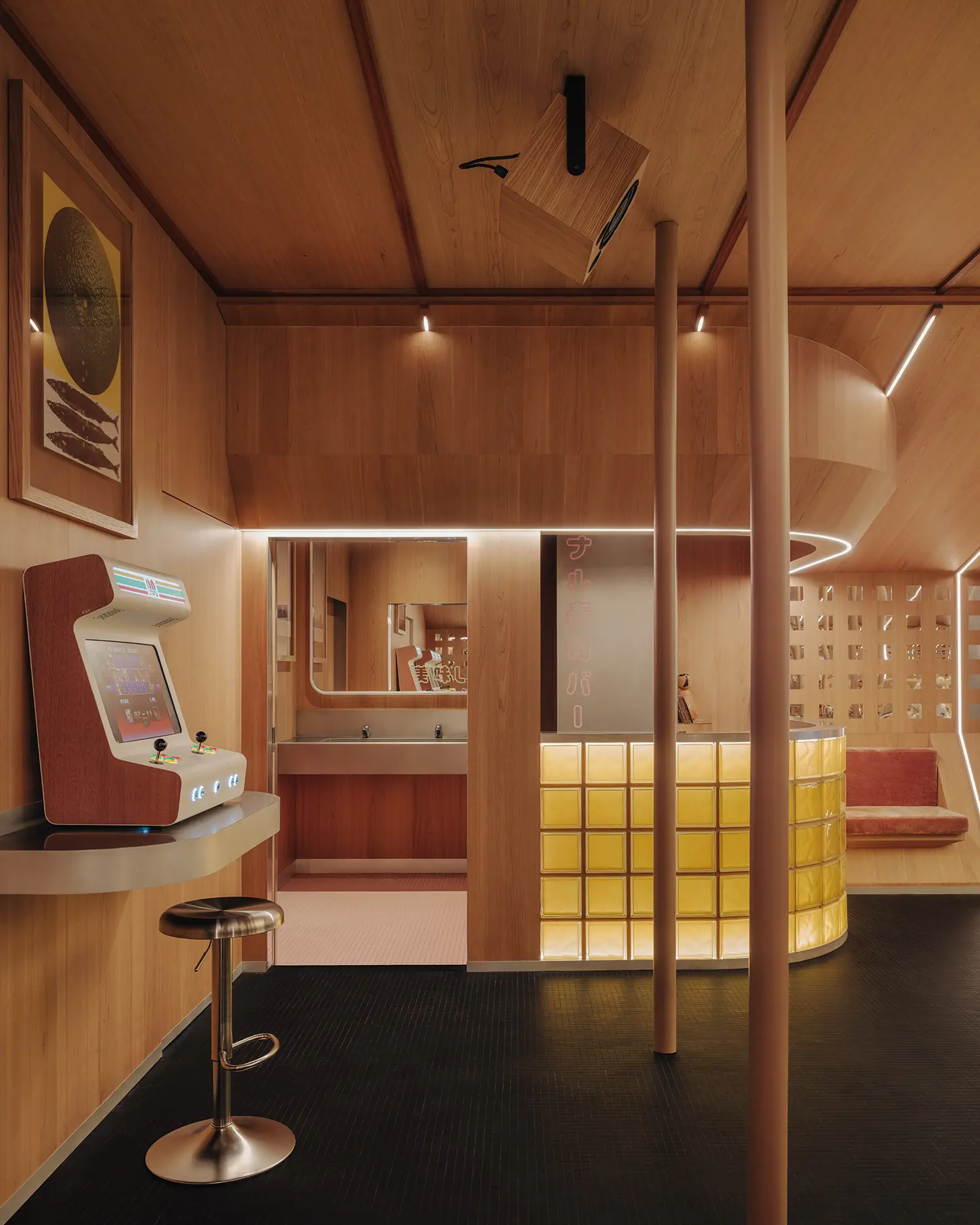 Retro-futuristic bar corner in Matsuri Marseille with a glowing yellow glass block counter, a custom timber hanging speaker, and a tabletop arcade console.