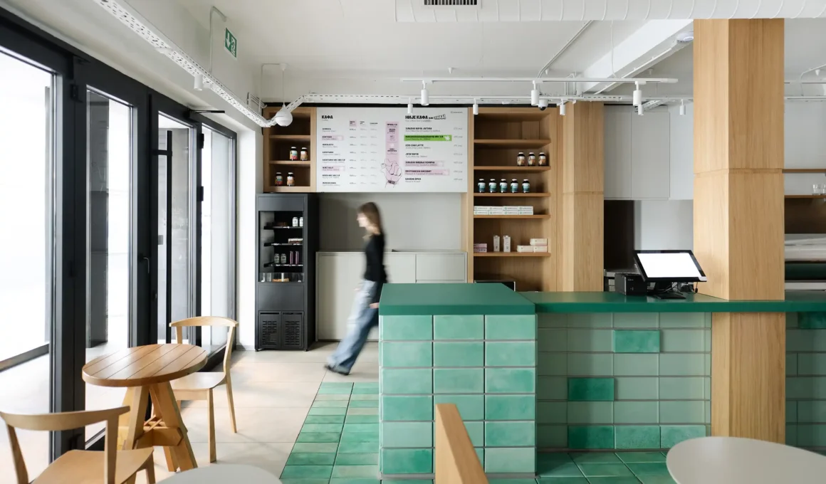 Interior of Kafeterija Vračar in Belgrade featuring a green tiled bar and wooden furniture.